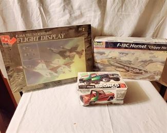 Three model planes, two unopened in original packing. The third is a model car from 1979.