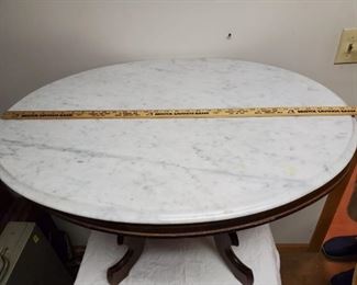 Marble top coffee table, white oval marble top, center finial in base, top measures approx. 33 inches long.
