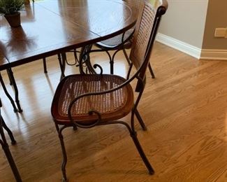 Oval Dining Room Table with Cast Iron Legs and Cane Back Chairs with Cast Iron Arms and Legs