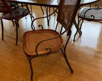 Oval Dining Room Table with Cast Iron Legs and Cane Back Chairs with Cast Iron Arms and Legs
