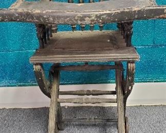 Antique oak child's children's highchair folds into a child's walker with wheels.