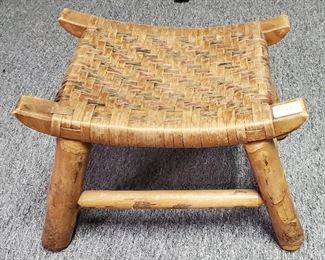 Primitive hand made milking or spinning stool with woven seat.