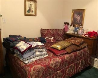 Double bed, comforters, pillows, dolls