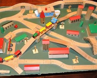 FANTASTIC VINTAGE BRIO TRAIN AND TRACK SET ASSEMBLED AND AFFIXED ON A GREEN BOARD. COMPLETE WITH 50 PIECES OF BRIO WOODEN TRACKS, 7 BRIO STRUCTURES, 12 ADDITIONAL BUILDINGS, AND 12 MISC. ITEMS. SET INCLUDES AN ADDITIONAL CASE FILLED WITH 87 ADDITIONAL PIECES OF TRACK, BRIDGES AND CONNECTORS. 32" X 48".  OUR PRICE $225.00