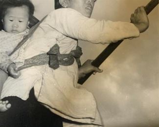 Photograph of Asian Mother with Child on Her Back

