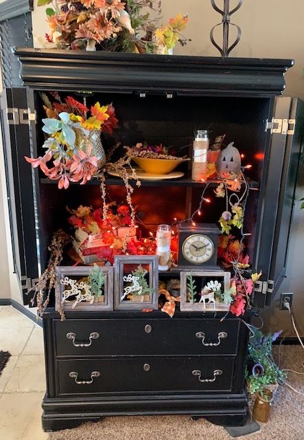 Beautiful, black armoire with holes in back for TV cables.