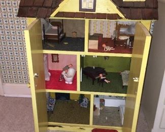 a precious wooden doll house filled with lots of vintage furniture