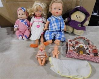 lot of children's baby dolls and a teddy bear