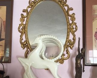 Oval gilded mirror and ceramic ram.