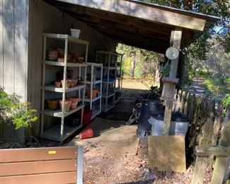 Lots of plastic shelving, flower pots, garbage cans