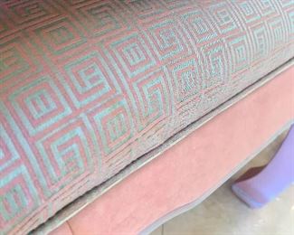 Teal and pink fabric upholstered on the benches beneath the console table.