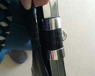 Black lizard skins clutch. Skins disconnecting from metal top on one side. Otherwise, very good condition.