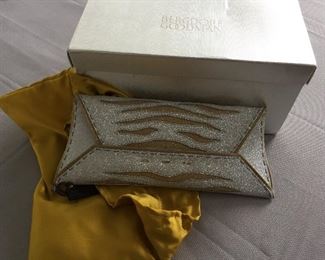 GOLD AND SILVER SPARKLY GLITTER CLUTCH
Condition: Pristine
Grey suede lining. Single wall pocket at interior. Fold-in flap closure at front flap
Dimensions: Width: 12". Height: 5"