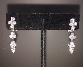 1.96 CTW DIAMOND F-G SI1 18K WHITE GOLD SWING DROP EARRINGS
Appraisal Report is included in this sale.
One pair stamped and tested 18KT white gold lady's hand assembled diamond drop earrings.
Prong set. Omega clip backs with posts. Bright polish finish. Identified markings of "18kt/750"
Total weight of diamonds: 1.96 ct
Total weight of diamond drop earrings: 5.60 grams
Contains:
Two prong set pear shaped cut diamonds (depth est.) exact total weight 2 stones = 0.41 ct.
Clarity SI1
Color G
Cut Excellent
Twenty prong set round brilliant cut diamonds exact total weight 20 stones = 1.55 ct.
Clarity SI1
Color F-G
Cut: Excellent
Length of earring: Approximately One and one-quarter inch
Width of earring: Approximately 1/4 inch at its widest
Condition: Excellent