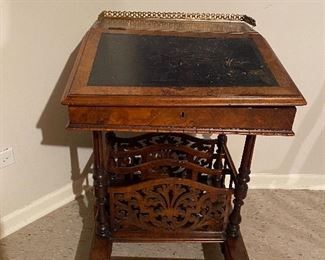 Antique davenport desk with leather slant top and brass filigree rail