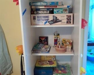 Utility shelf filled with games, crayons, art supplies and morr