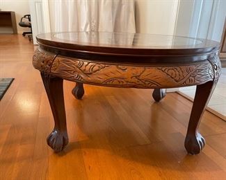 Asian carved coffee table with intricate carvings and glass top. 