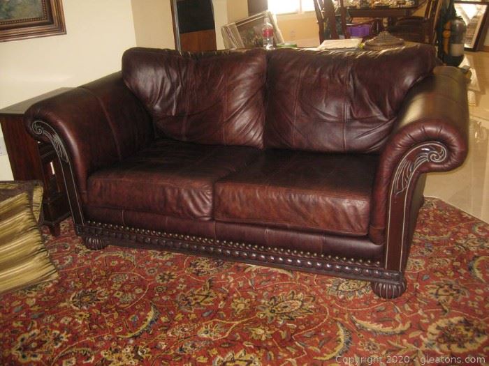Rolled Arm Leather Loveseat with Wooden Base Plus Nail Head Trim