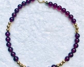14k yellow gold and garnet bead bracelet, measuring 7" long, and weighing 5.0g.  $98