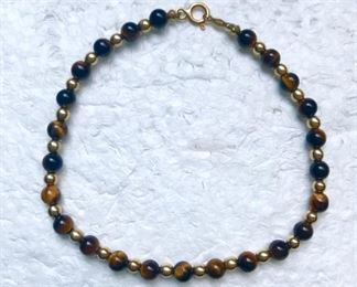 14k yellow gold and polished tiger's eye beaded bracelet, measuring 7.25" long, and weighing 3.3g.  $120
