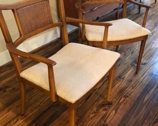 Pair of Mid-Century Modern armchairs with upholstered seats and woven wicker back splats