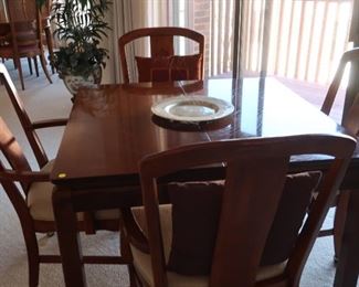 cherry table  and  chairs  it  is  40"  x  40".  There  are  also 2 18"  leaves. It  also  has  pads.  The  chairs  are  on  wheels