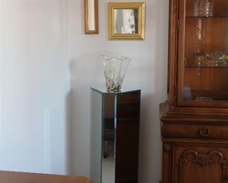 another  glass covered  pedestal  and  mirror  decor  above