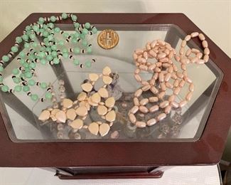 8. Small tabletop curio with jewelry and figureines inside as well as a pair of mother of pearl opera glasses binoculars. Some antique foreign coins as well.    One pin which is a marked piece of 14k Gold (shown with coins) $125 all