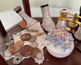 8. Small tabletop curio with jewelry and figureines inside as well as a pair of mother of pearl opera glasses binoculars. Some antique foreign coins as well.    One pin which is a marked piece of 14k Gold (shown with coins) $125 all