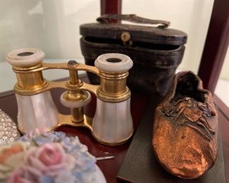 8. Small tabletop curio with jewelry and figureines inside as well as a pair of mother of pearl opera glasses binoculars. Some antique foreign coins as well.    One pin which is a marked piece of 14k Gold (shown with coins) $125 all