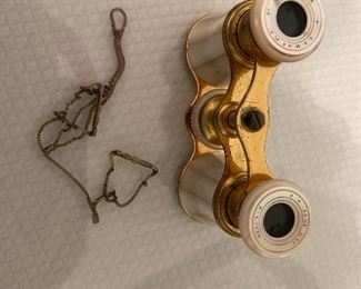 8. Small tabletop curio with jewelry and figureines inside as well as a pair of mother of pearl opera glasses binoculars. Some antique foreign coins as well.    One pin which is a marked piece of 14k Gold (shown with coins) $125 all