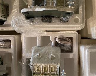 40. Hawthorne Village and Ashton Drake Christmas Village lot.  There a few Small accessory pieces in the blue tub.   Boxes leaning on wall are bases for ice skating rinks, etc.  The Christmas tree is awesome!  $195  all