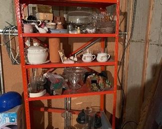 75. Orange metal shelf wtih contents including sugar and creamers, old glassware, tea kettle, two light fixtures and more (Fan in box on left not included) $50