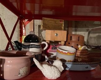 75. Orange metal shelf wtih contents including sugar and creamers, old glassware, tea kettle, two light fixtures and more (Fan in box on left not included) $50