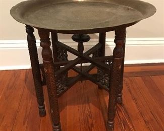 Engraved brass tray atop intricately carved folding stand. Losses to stand, tray dented. Still a stunner - 21” H x 21” W | $90