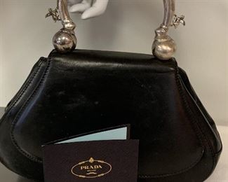 Vintage Leather PRADA Handbag - silver handle is adorned with two pegasus figurines on each side.  Inside pocket is damaged and needs repair. Light wear/marks to the outside leather. Measures about 10.5" x 7.5" 