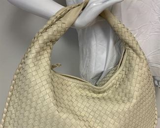 Bottega Veneta Handbag in ivory shade of leather. Card inside notes, "the leather for this handmade product is naturally dyed and untreated." This handbag also comes with a small hand-held mirror. Inside of purse has a zipper compartment. Measures  about 19"w X 12" H