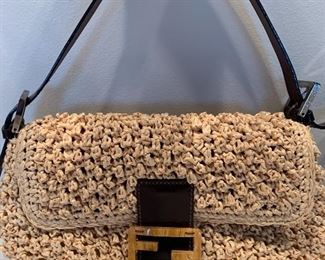 Fendi Baguette Handbag. Amazing handbag by Fendi. Straw-like material/design with leather detail. Features an inside zipper compartment and measures about 11" x 6.5"  This handbag was not authenticated, but does appear to be authentic as it comes from the same household as the other genuine handbags. 