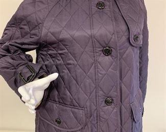 Very nice ladies Burberry jacket in a lovely shade of purple. Features two front pockets and "Burberry" buttons. The trademark Burberry print lines the inside of the jacket. Made in England. Inside collar in the back, has some light marks - possibly from make up and would likely come out after a cleaning. Size M. 