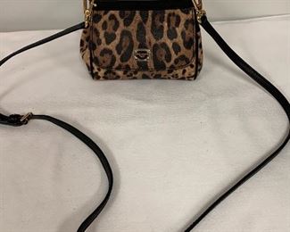 Dolce and Gabbana "The Sicily (Mini) Handbag" How fun is this lovely handbag! A timeless classic by Dolce and Gabbana. Very gently used; may not have even been used. Still has the protective film the Dolce and Gabbana metal tag on the front.  Features an on top handle and adjustable strap and  interior pocket; made of calf skin. Made in Italy. 