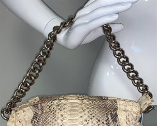 This exquisite handbag has a decorative silver chain strap that is 11 inches in length and 4 inches in height. The handbag is 12 by 8 inches.  The "fabric" appears to be snakeskin. 