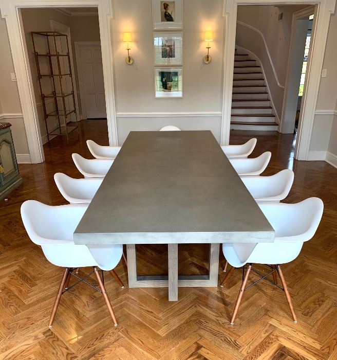 $2200 Restoration Hardware Heston Rectangular Dining Table, This Gorgeous Concrete Solid table features natural weathered reclaimed pine rectangular cube base with interlocking planes. 120”x42”x30” Retails for $3395                                                                               $50/Chair Also Pictured are 10 Mid Century Style White Dowel Leg Armchairs each with plastic seat features a rounded construction for added comfort and stability 22"x20.5"x31" 