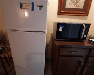 Apartment size refrigerator; Samsung Microwave; needlepoint picture