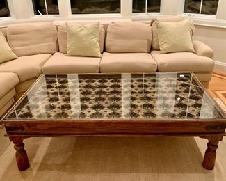 Item 51:  Hand Carved Indonesian Coffee Table + Glass Top. Encased within the glass are architectural salvage discs placed amongst the carvings. Solid wood framing surround the top with hardware. Coffee table - 62"l x 34.5"w x 18.5"h:  $450
