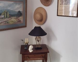 framed prints, lamp, straw hats, side table