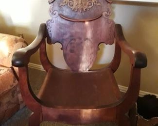 Unique wooden chair with carved sun motif.