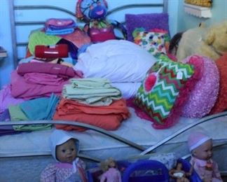 Dolls, bed linens, pillows, and art.
