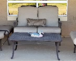 Patio loveseat and side chairs. One chair is a glider. Patio coffee table.