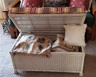Wicker trunk that opens for storage. Great for extra seating.