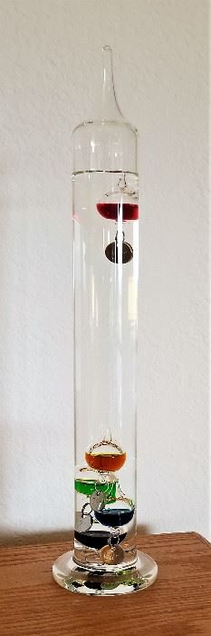 Galileo Thermometer not only does this instrument tell temperature in Fahrenheit, it is also a work of beauty and art!
When the temperature rises, the liquid inside the glass tube becomes less dense and the colorful, liquid-filled bulbs will sink. When the temperature of the room cools, the process is reversed and bulbs will rise from the bottom. Station it on a tabletop and enjoy the wonders of science at work!